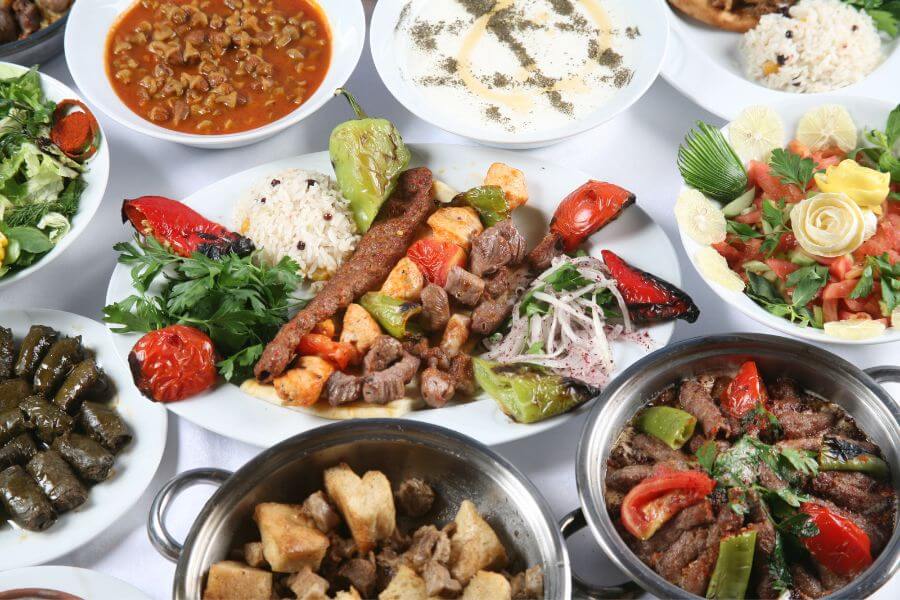 Delicious Turkish kebap served with grilled vegetables and rice on a traditional ceramic plate.