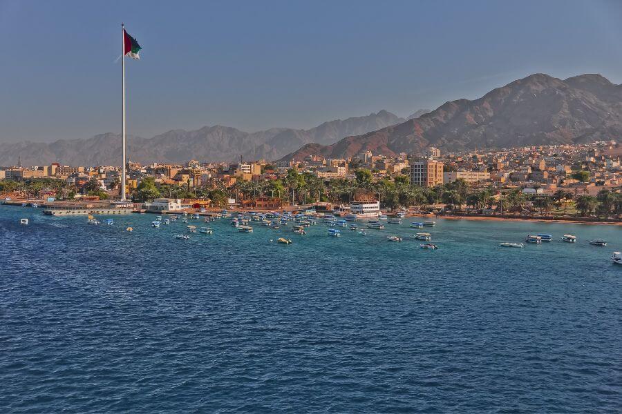 Vibrant view of Aqaba City featuring the Red Sea coastline, modern architecture, and bustling port activities.