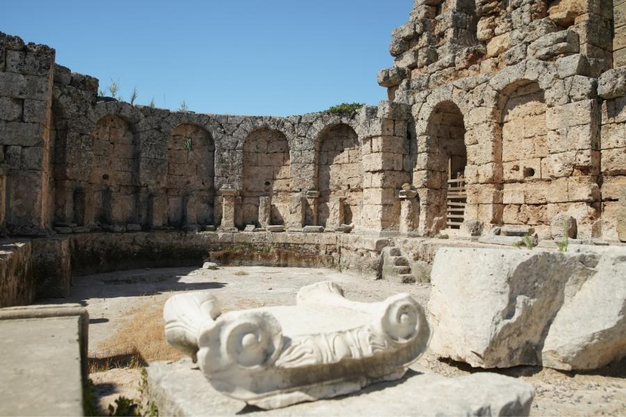 Stone arches and carved marble remains at the Roman Baths of Perge, Turkey, highlighting ancient architecture and craftsmanship.