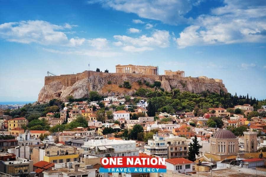 Scenic view of the Acropolis in Athens, Greece, featuring the Parthenon and surrounding historic cityscape under a vibrant sky.