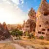 Panoramic view of Goreme Open Air Museum with intricate cave churches and unique rock formations under a clear sky.