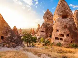 Panoramic view of Goreme Open Air Museum with intricate cave churches and unique rock formations under a clear sky.