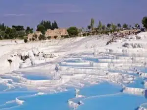 White terraces of Pamukkale Hot Springs in Turkey, reflecting sunlight.