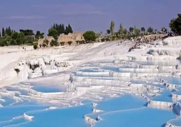 White terraces of Pamukkale Hot Springs in Turkey, reflecting sunlight.