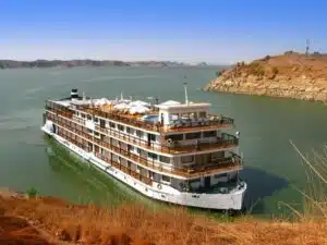 Luxurious Nile cruise ship sailing past ancient Egyptian landmarks.