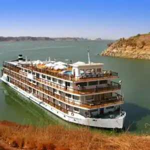 Luxurious Nile cruise ship sailing past ancient Egyptian landmarks.