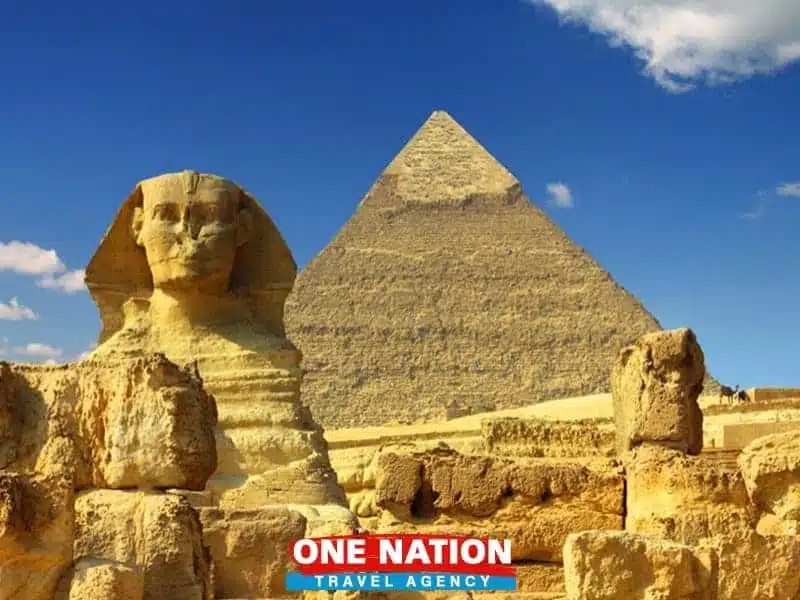 a group of stone statues in front of a pyramid