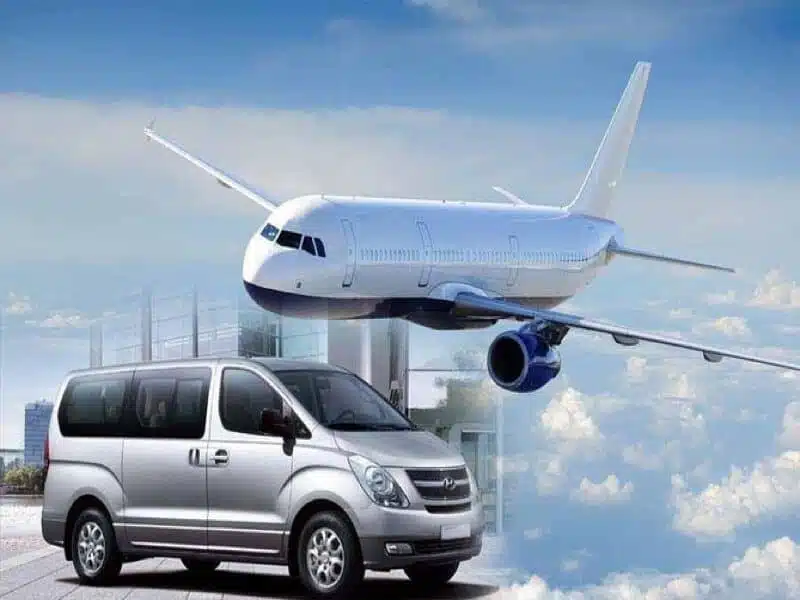 a plane flying over a silver van