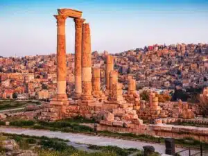 Amman cityscape featuring modern high-rise buildings and ancient ruins, highlighting its blend of contemporary and historic architecture.