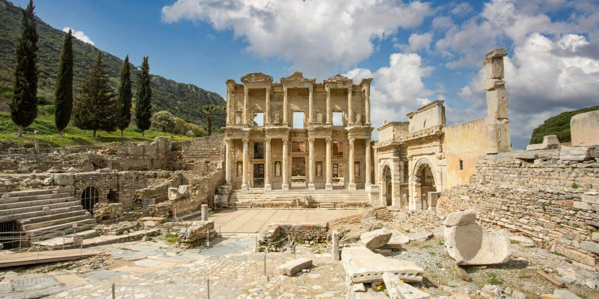 Front view of the Celsus Library in Ephesus, Turkey with grand marble columns and ornate Roman architecture.
