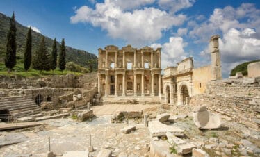 Front view of the Celsus Library in Ephesus, Turkey with grand marble columns and ornate Roman architecture.