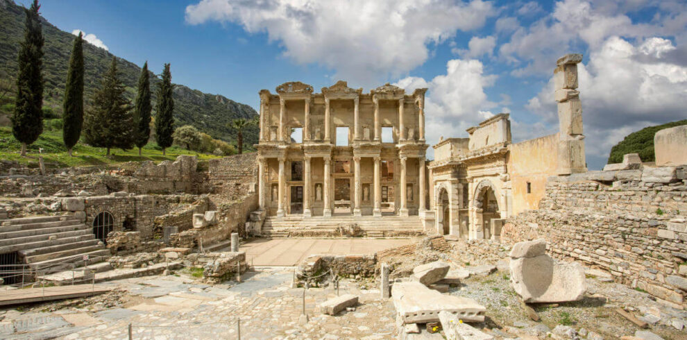 Front view of the Celsus Library in Ephesus, Turkey with grand marble columns and ornate Roman architecture.
