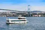 Scenic view of a Bosphorus cruise ship sailing through Istanbul, showcasing historic landmarks and city skyline.