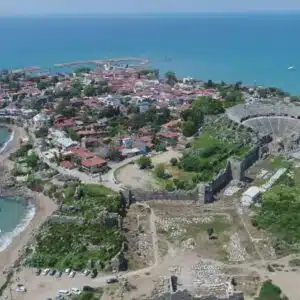 Panoramic view of Side city in Antalya, Turkey, showcasing ancient ruins and modern buildings, viewed from a hill.