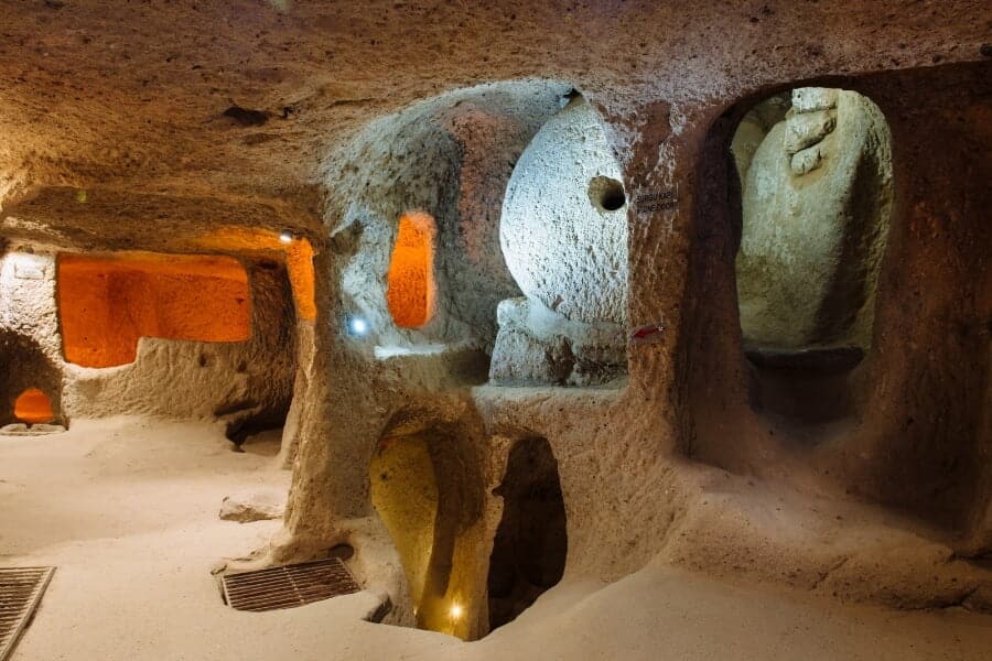 Narrow stone passageways inside Derinkuyu Underground City, carved from rock, showcasing ancient engineering.