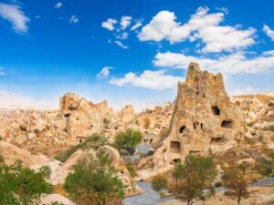 A scenic view of Goreme Open Air Museum featuring ancient cave churches and frescoes in a rocky landscape.