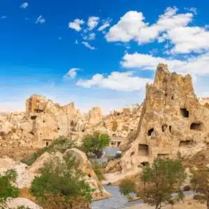A scenic view of Goreme Open Air Museum featuring ancient cave churches and frescoes in a rocky landscape.