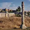 Ruins of the Temple of Artemis at Ephesus under a vibrant sunset, casting long shadows over ancient stones.