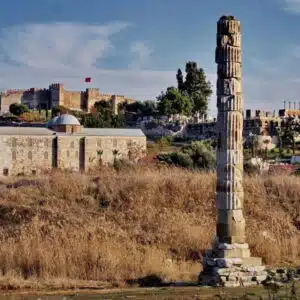Ruins of the Temple of Artemis at Ephesus under a vibrant sunset, casting long shadows over ancient stones.
