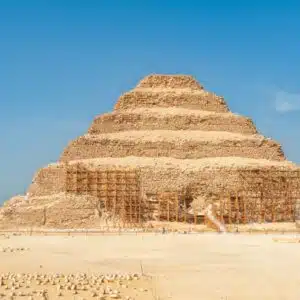 View of Saqqara Necropolis in Egypt, showcasing ancient pyramid structures, tombs, and desert landscape under a clear sky.