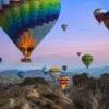 Cappadocia hot air balloons rising at dawn over unique rock formations.