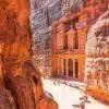 Tourist exploring the ancient city of Petra in Jordan, showcasing iconic sandstone architecture.