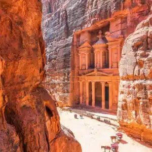 Tourist exploring the ancient city of Petra in Jordan, showcasing iconic sandstone architecture.