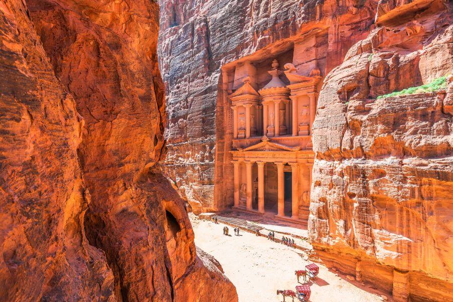 Tourist exploring the ancient city of Petra in Jordan, showcasing iconic sandstone architecture.