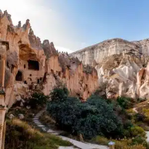 For an outdoor image of the Zelve Open Air Museum, consider this description: "Panoramic view of Zelve Open Air Museum, showcasing weathered rock formations and cave entrances under a clear blue sky.