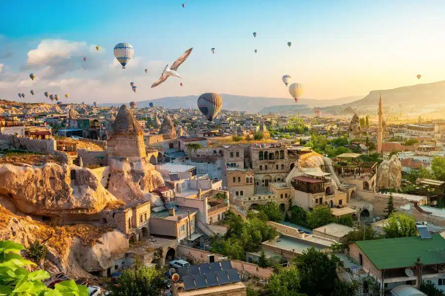 Comprehensive Cappadocia travel guide featuring the unique landscape of fairy chimneys, hot air balloons at sunrise, and ancient cave dwellings, highlighting must-visit sites and activities for explorers.