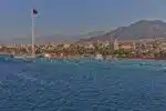 Vibrant view of Aqaba City featuring the Red Sea coastline, modern architecture, and bustling port activities.