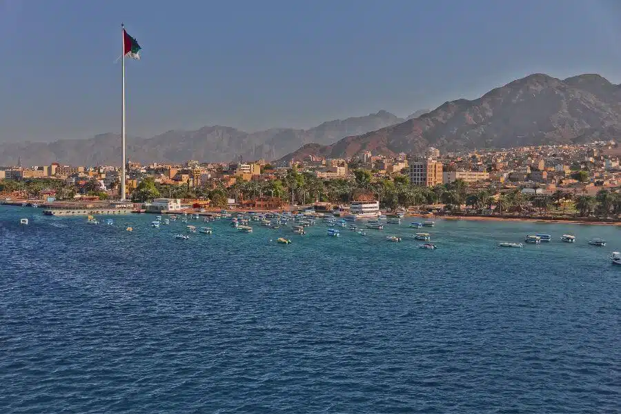 Vibrant view of Aqaba City featuring the Red Sea coastline, modern architecture, and bustling port activities.