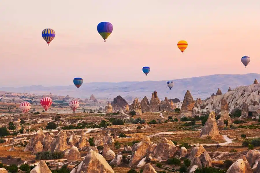 Hot air balloons soaring over the breathtaking rock formations and fairy chimneys of Cappadocia, Turkey, during sunrise