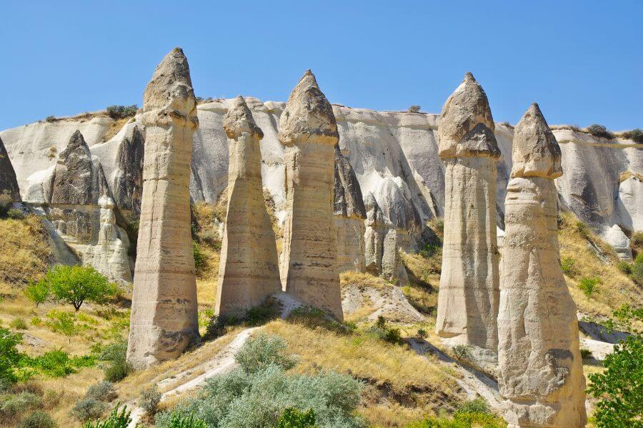 A breathtaking view of Fairy Chimneys in Cappadocia, Turkey, with unique rock formations and hot air balloons in the sky.