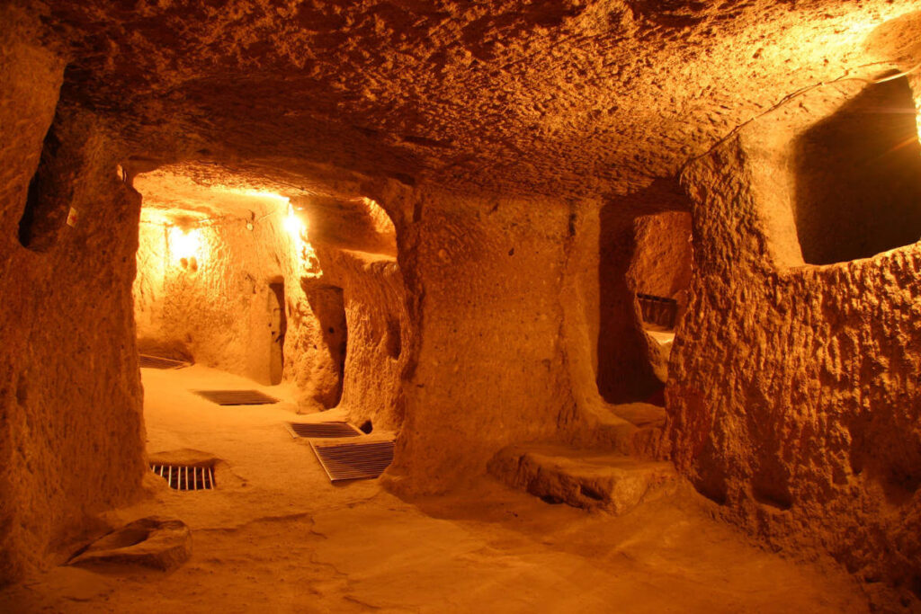 Narrow, dimly lit tunnels and chambers carved from rock in Kaymakli Underground City, Cappadocia, Turkey.