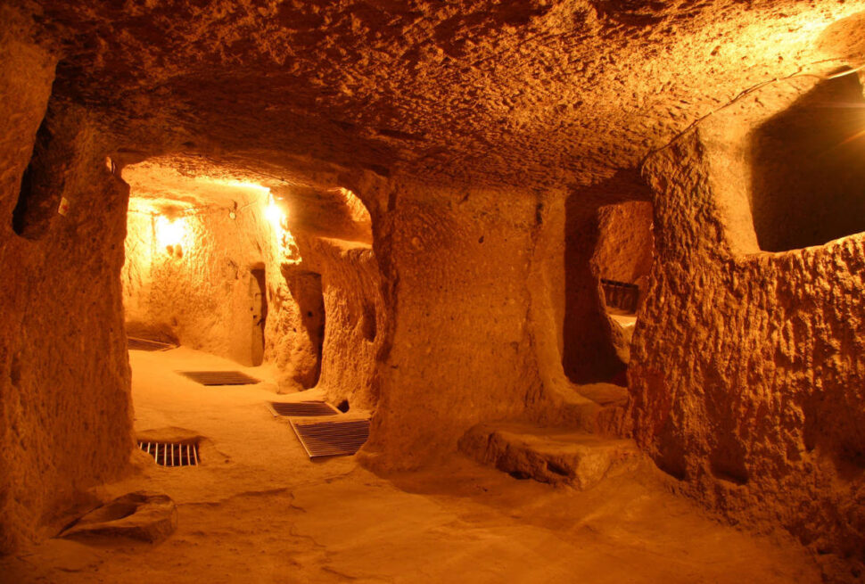 Narrow, dimly lit tunnels and chambers carved from rock in Kaymakli Underground City, Cappadocia, Turkey.