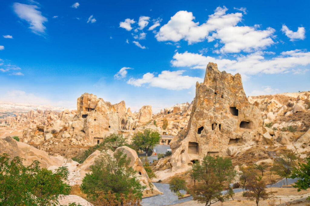 Ancient cave churches and rock-cut monasteries at Göreme Open-Air Museum in Cappadocia under a bright blue sky.