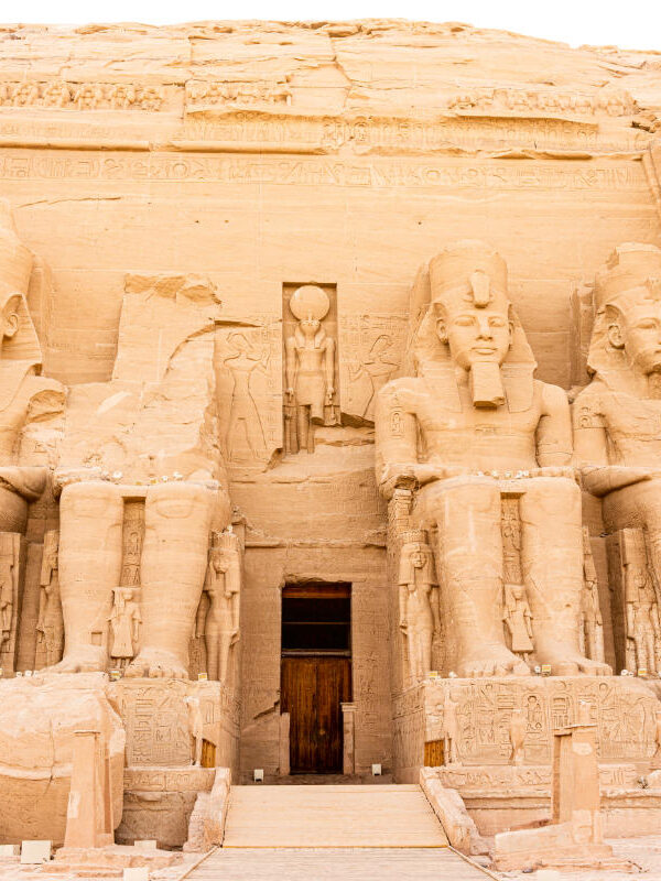 Abu Simbel Temple in Egypt featuring four colossal seated statues of Pharaoh Ramesses II carved into a sandstone cliff.