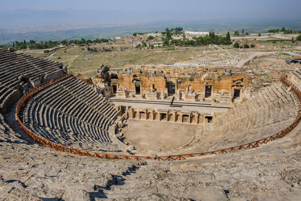Panoramic view of the Ancient Theatre of Hierapolis in Pamukkale, Turkey, with stone seating and preserved Roman stage.