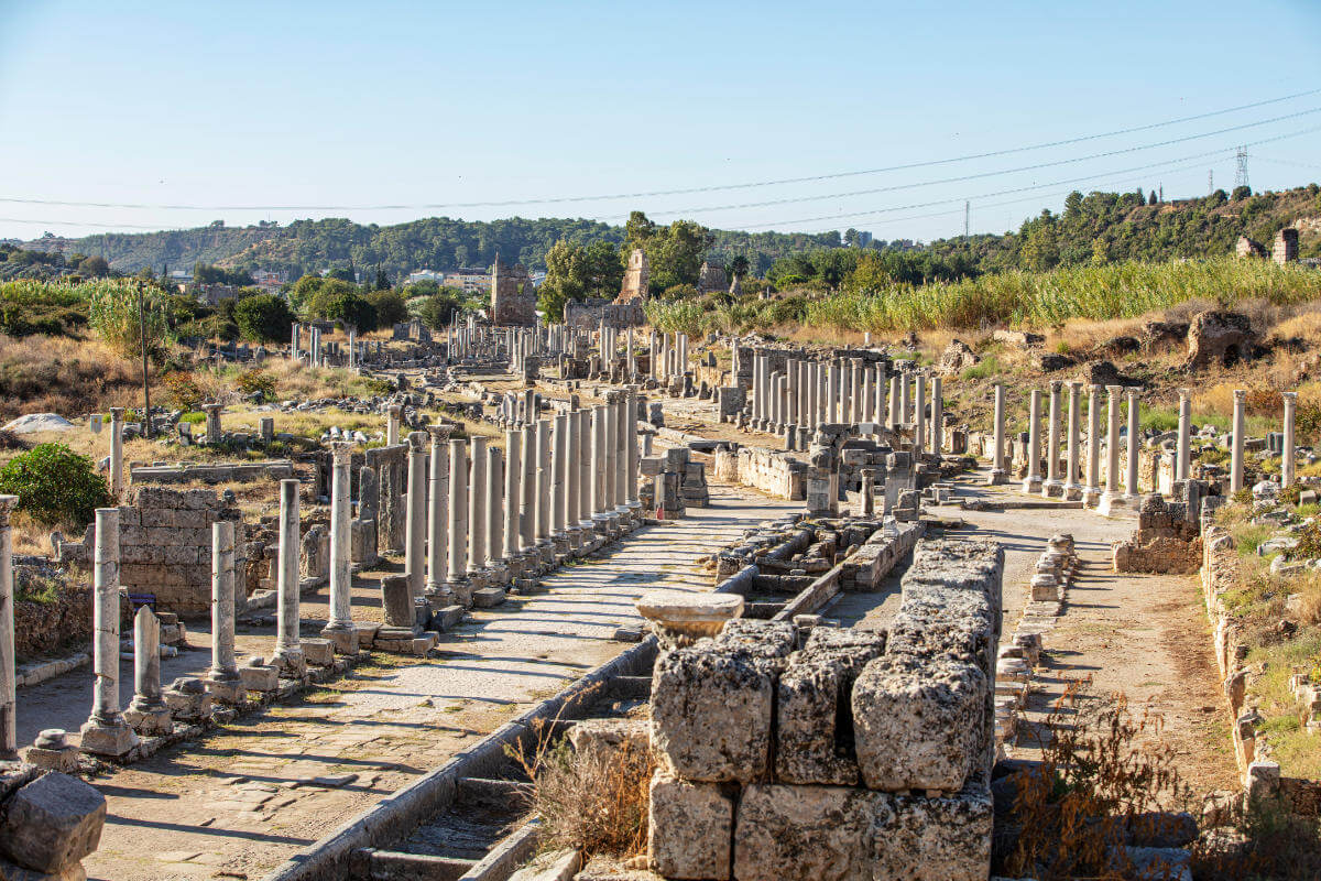 Ruins of the ancient agora in Perge, Antalya, Turkey, featuring stone columns and walkways from the Roman period.