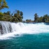8-Day Gallipoli, Troy, Pergamon, Ephesus, Pamukkale, Antalya & Cappadocia Tour - Cappadocia, Ephesus, Pamukkale, Antalya, Troy, Gallipoli, Turkey Vista panorámica de la cascada de Manavgat en Antalya, Turquía, con aguas turquesas que fluyen sobre una amplia cornisa rocosa.