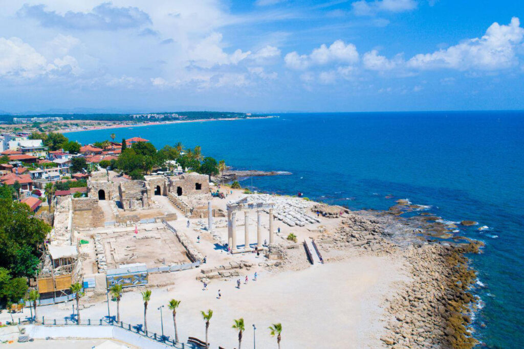 Ruins of the Temple of Apollo on the Mediterranean coast in Side, Antalya, Turkey, with white columns and sea view.