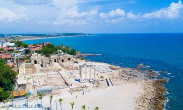 Ruins of the Temple of Apollo on the Mediterranean coast in Side, Antalya, Turkey, with white columns and sea view.