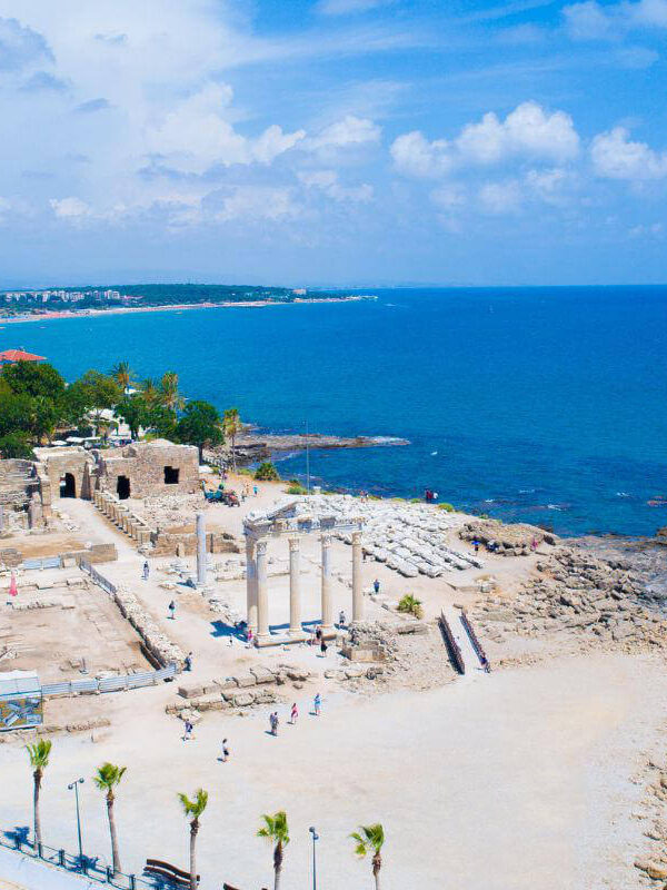 Ruins of the Temple of Apollo on the Mediterranean coast in Side, Antalya, Turkey, with white columns and sea view.