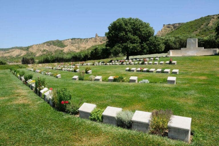 View of Beach Cemetery at Gallipoli Peninsula in Çanakkale, Turkey, with aligned gravestones and sea in the background.