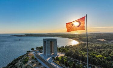 Çanakkale Martyrs' Memorial with Turkish flag waving at sunset in Gallipoli Peninsula, Çanakkale, Turkey.
