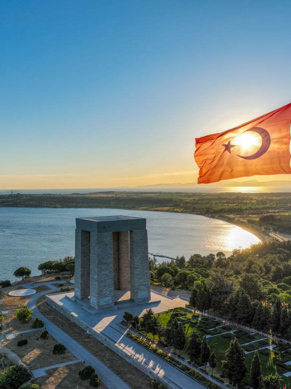 Çanakkale Martyrs' Memorial with Turkish flag waving at sunset in Gallipoli Peninsula, Çanakkale, Turkey.