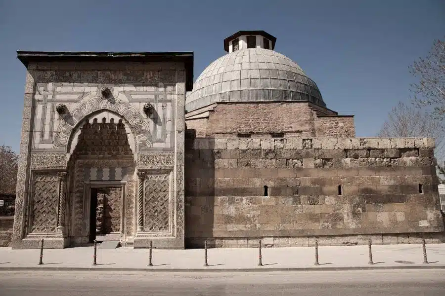 Front view of Karatay Madrasa Mosque in Konya, featuring a decorative arched entrance and a large stone dome, typical of Seljuk design.