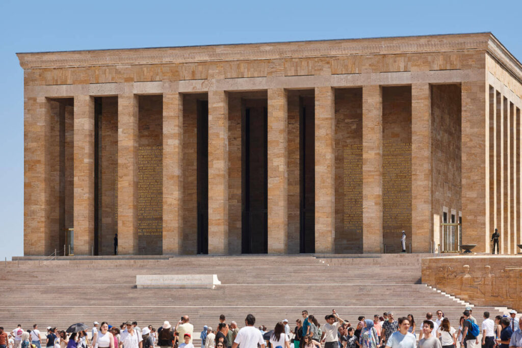 Crowds at Anıtkabir, the grand mausoleum of Mustafa Kemal Atatürk in Ankara, with tall columns and stone facade.