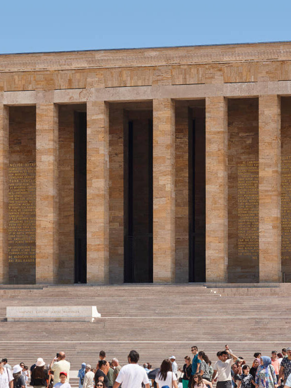 Crowds at Anıtkabir, the grand mausoleum of Mustafa Kemal Atatürk in Ankara, with tall columns and stone facade.